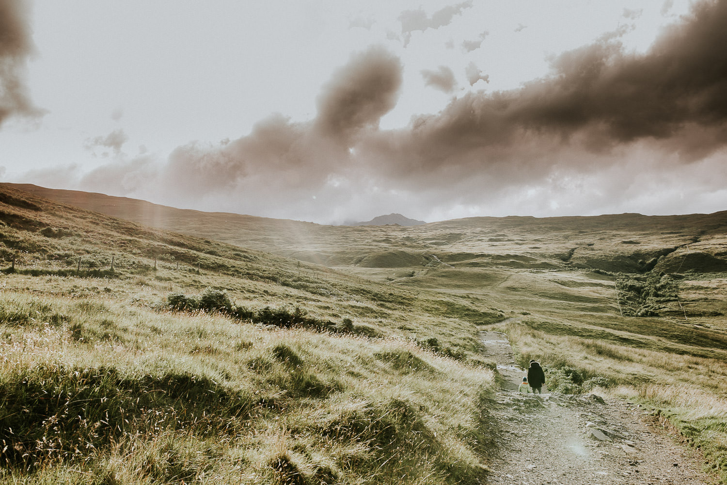 Mann und Kind wandern durch die Berge auf der Isle of Skye
